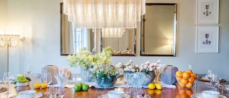 A dining table set for a meal with various dishes, glasses, and a centerpiece of flowers.