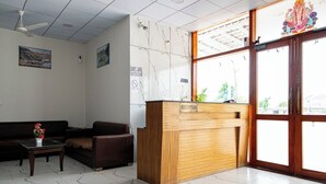 Ein Empfangsbereich mit einem Holztisch, einer Couch und einem Couchtisch.