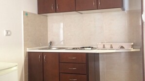 Una cucina con mobili marroni, un piano di lavoro bianco e un lavello.