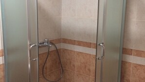 Box doccia con porta in vetro, soffione e doccetta a mano.