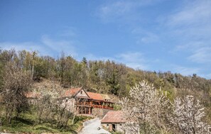 A rustic cabin with a red roof, surrounded by a forested hillside. - Beautiful home in Lepoglava with WiFi (Lepoglava)