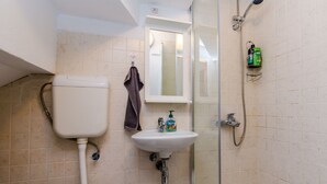 Une salle de bain avec des toilettes, un lavabo et une douche.