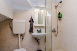 Ein Badezimmer mit Toilette, Waschbecken und Dusche.