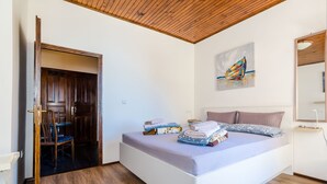 Une chambre à coucher avec un lit, un tableau, un miroir et un plafond en bois.