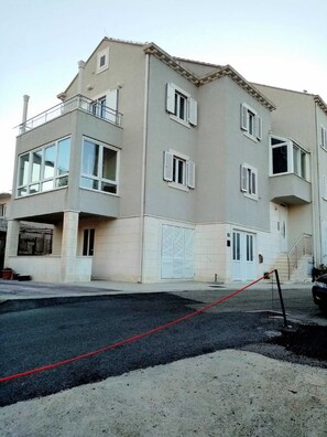 Ein mehrstöckiges Gebäude mit flachem Dach, großen Fenstern und einem Balkon.