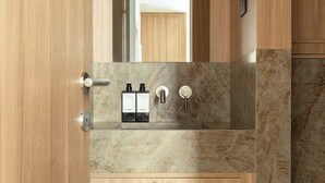 A modern bathroom with wooden cabinetry, a marble countertop, and a mirror. - Sublime Suite Saint Honore, Elysee Palace (Paris)
