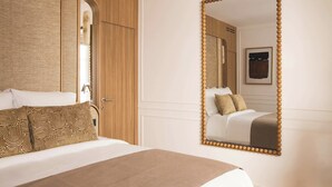 A hotel room with a bed, a large mirror, and a wardrobe. - Sublime Suite Saint Honore, Elysee Palace (Paris)