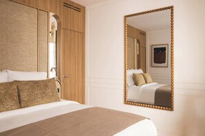 Ein Hotelzimmer mit einem Bett, einem großen Spiegel und einem Kleiderschrank.