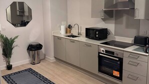 A modern kitchen with a microwave, oven, and sink. - Apartment in Botanical Gardens, Old Trafford (Stretford, old Trafford)