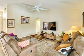 A living room with a ceiling fan, a flat-screen TV, a coffee table, and a sofa with decorative pillows. - Near Disney & Top Attractions! Poolside Oasis (Davenport)