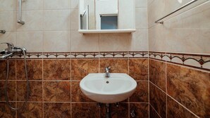 A bathroom with a white sink, a shower, and a mirror above the sink. - Studio Apartment (Baska Voda)