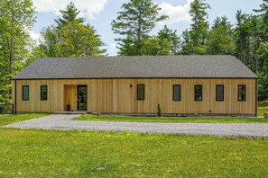 A wooden building with a sloped roof, a gravel driveway, and a grassy area in front. - Catskills New Build w/ Private Hot Tub & Fire Pit! (Cairo)