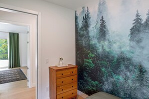 A bedroom with a large forest mural, a wooden dresser, and a bed. - Catskills New Build w/ Private Hot Tub & Fire Pit! (Cairo)