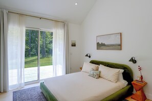 A bedroom with a bed, a window with curtains, a painting on the wall, and a nightstand with a lamp. - Catskills New Build w/ Private Hot Tub & Fire Pit! (Cairo)