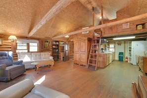 Ein Blockhaus-Interieur mit Wohnzimmer, Küche und Schlafzimmer im Obergeschoss.