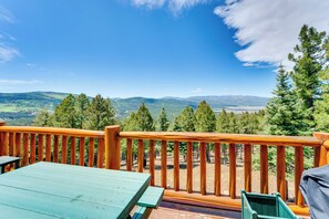 Eine Holzterrasse mit Blick auf eine gebirgige Landschaft.