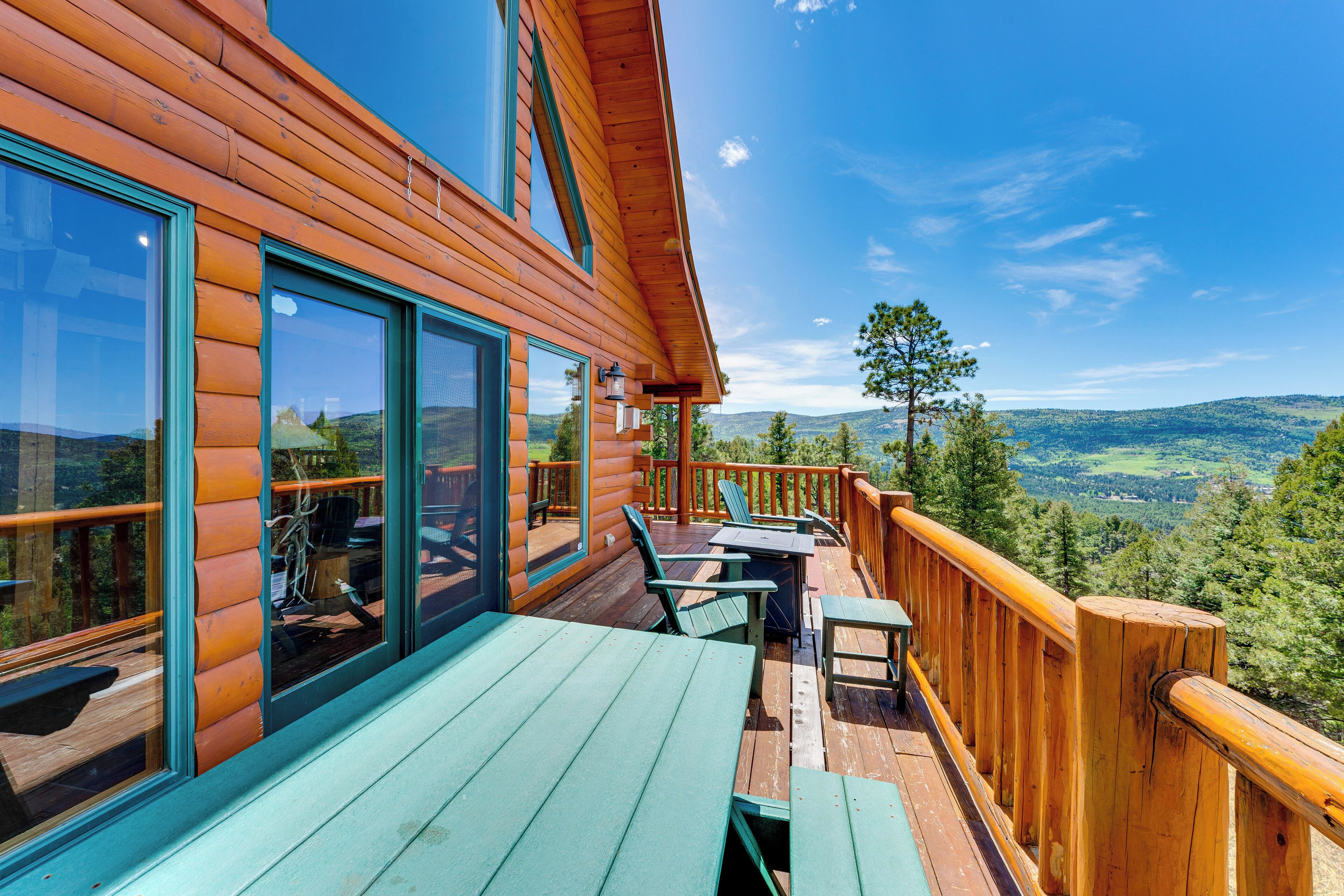 A wooden deck with outdoor seating and a scenic view.