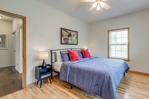 A bedroom with a bed, a nightstand, a lamp, a ceiling fan, a window with blinds, and a framed picture on the wall. - 8-Acre Family Reunion Retreat! 8 Mi to Bentonville (Pea Ridge)