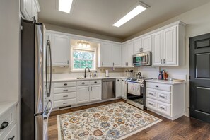A kitchen with white cabinets, a stainless steel refrigerator, a microwave, an oven, and a dishwasher. - 8-Acre Family Reunion Retreat! 8 Mi to Bentonville (Pea Ridge)