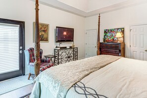 A bedroom with a four-poster bed, a television, a desk with a lamp, and a door. - Mid-Term Stay Near Lake Oconee! Home w/ Gazebo (Greensboro)