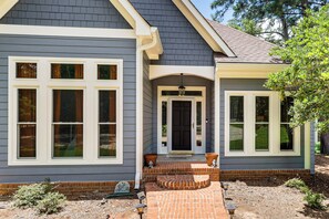 A two-story house with a brick entryway, a black front door, and a welcoming sign. - Mid-Term Stay Near Lake Oconee! Home w/ Gazebo (Greensboro)