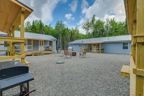 A campground with two cabins, outdoor seating, and a barbecue grill. - Off-Road Fun! Downeast Sportsman Studio (Wesley)