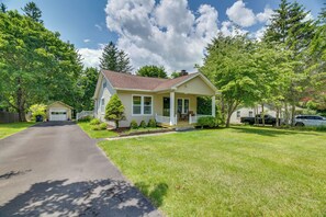 A single-story house with a front porch, a garage, and a well-maintained lawn. - Family-Friendly Poconos Getaway 11 Mi to Kalahari! (Cresco)