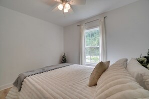 Ein Schlafzimmer mit Bett, Fenster und Deckenventilator.