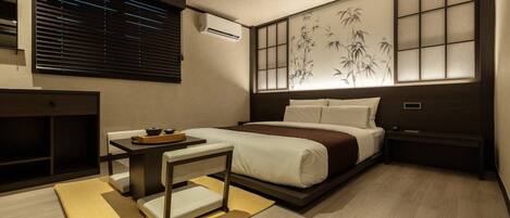 A modern hotel room with a bed, bedside table, and a traditional-style wall decoration.
