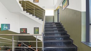 A staircase with metal railings and granite steps, flanked by walls with artwork.