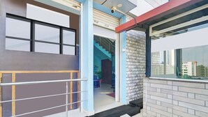 A building entrance with a metal gate, a staircase, and a view of the cityscape. - Super Collection O by OYO Nayagaon Vikas (Chikkamagaluru)
