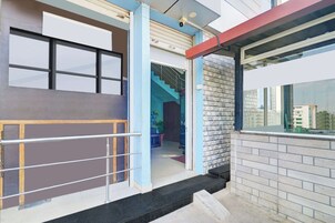 La entrada de un edificio con una verja metálica, una escalera y vistas de la ciudad.