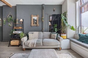 A cozy living room with a sofa, a coffee table, and a bookshelf. - Spacious 1BR in Near Arthur's Seat & Royal Mile (Edinburgh)