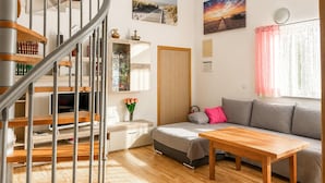 A modern living room with a staircase, a sofa, a wooden table, and a bookshelf. - 2 bedroom awesome apartment in Vir (Vir)