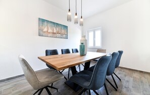 A dining area with a wooden table, six chairs, a vase, and a painting on the wall. - Awesome home in Debeljak (Debeljak)