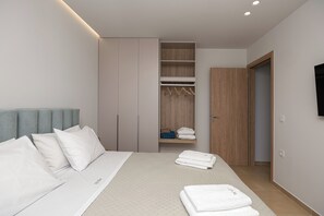 Un dormitorio con cama, armario y televisor.
