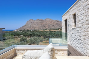 A balcony with a view of a mountain and a clear sky.
