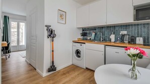 Une cuisine compacte équipée d’un lave-linge, d’un lave-vaisselle et d’un four à micro-ondes.