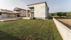 A modern two-story house with a flat roof, a balcony, and a well-maintained lawn. - Luxury D Apartments - Luxury Two Bedroom Apartment With Terrace A2 (Bibinje)