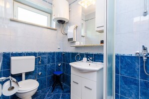 Ein Badezimmer mit Toilette, Waschbecken und Dusche.