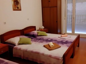 A bedroom with a bed, nightstands, a wardrobe, and a window with blinds. - Apartments Franka Saplunara-triple Room With Terrace and Sea View No1 (Mljet)