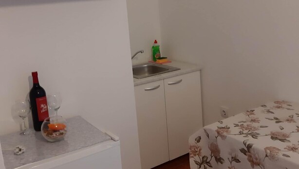 A small kitchenette with a sink, cabinets, and a countertop. - Apartments Franka Saplunara-triple Room With Terrace and Sea View No1 (Mljet)