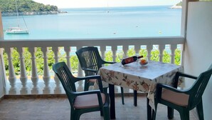 A balcony with a table and chairs overlooking a body of water. - Apartments Franka Saplunara-triple Room With Terrace and Sea View No1 (Mljet)