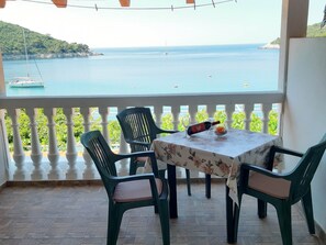 A balcony with a table and chairs overlooking a body of water. - Apartments Franka Saplunara-triple Room With Terrace and Sea View No1 (Mljet)