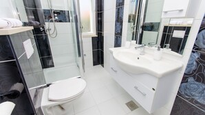 A modern bathroom with a glass-enclosed shower, a white sink, and a toilet. - Apartments Ivana - Studio With Balcony and Sea View (Trogir)