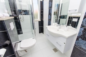 A modern bathroom with a glass-enclosed shower, a white sink, and a toilet. - Apartments Ivana - Studio With Balcony and Sea View (Trogir)