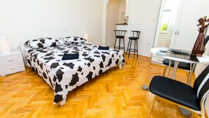 A bedroom with a bed, a desk, two chairs, a mirror, and a wardrobe. - Apartments Ivana - Studio With Balcony and Sea View (Trogir)