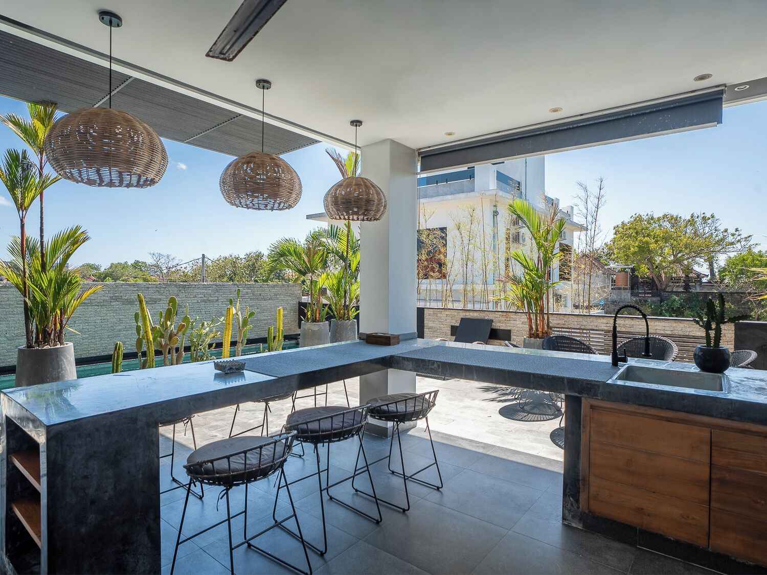 A modern kitchen with a large island, bar stools, and a view of the city.