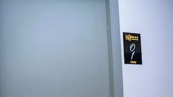 A door with a frosted glass panel and a black sign with yellow text on the wall.