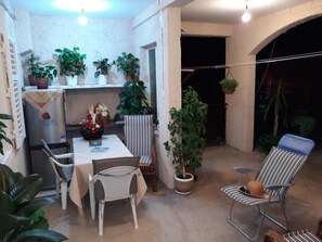 A patio area with a table, chairs, potted plants, and a hanging plant. - Holiday Home With Parking and 2 Rooms (Dubrovnik)